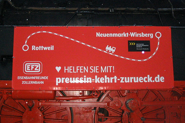Schild mit Aufschrift "Helfen Sie mit" an Lok 78-246 zeigt Strecke von Rottweil nach Neuenmarkt-Wirsberg, Logo der Eisenbahnfreunde Zollernbahn und den Weblink "preussin-kehrt-zurueck.de"
