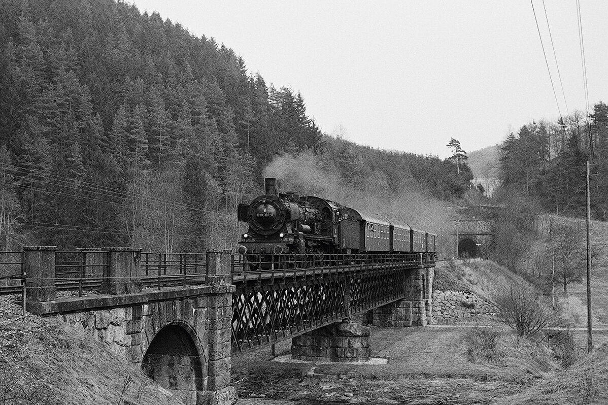 Steam locomotive 38-2383 crossing a bridge in black and white
