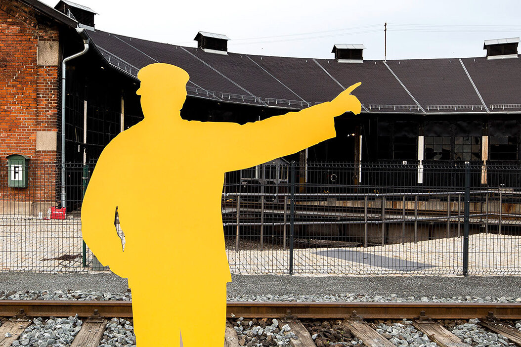 A yellow cutout figure points to the right