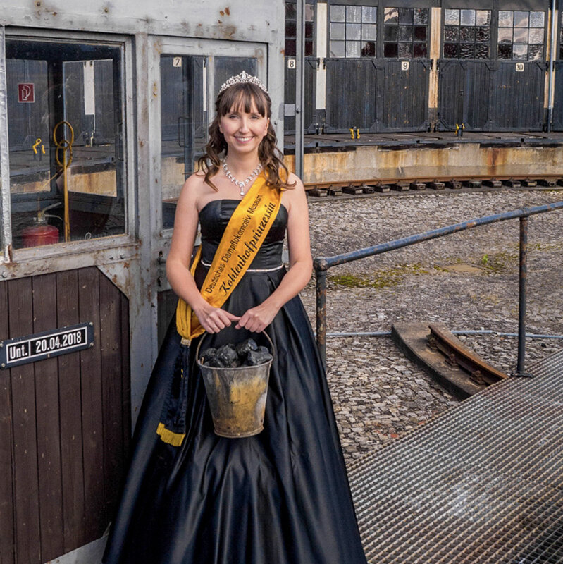 The princess of the coal yard Julia I. is holding a bucket of coal