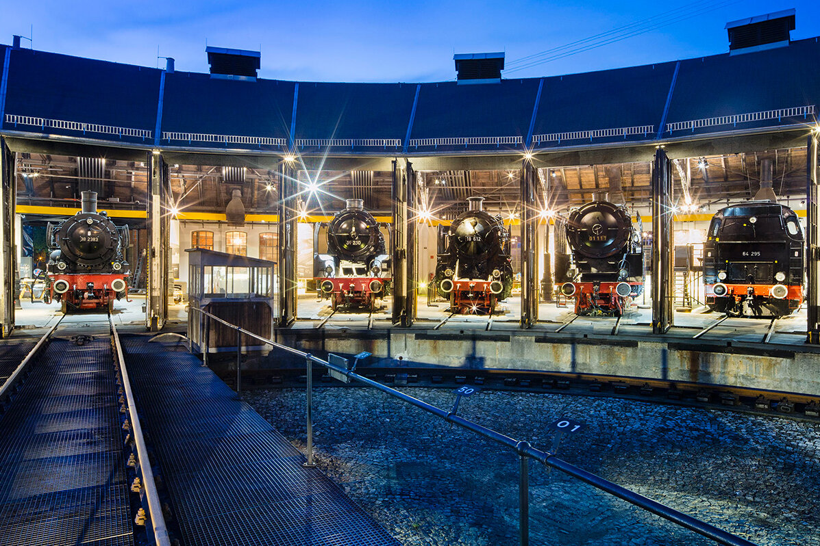 Locomotives inside the engine shed with open gates in the evening