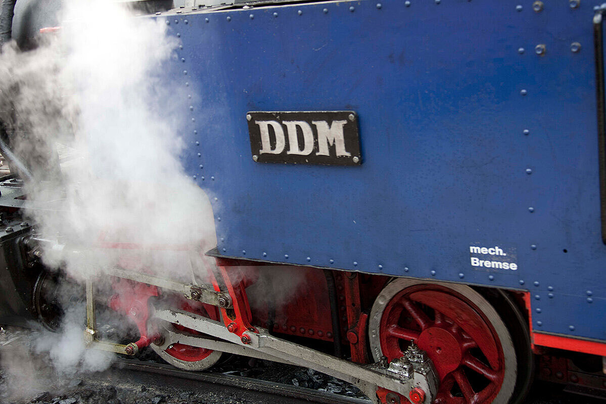 Smoke arising next to a small steam locomotive