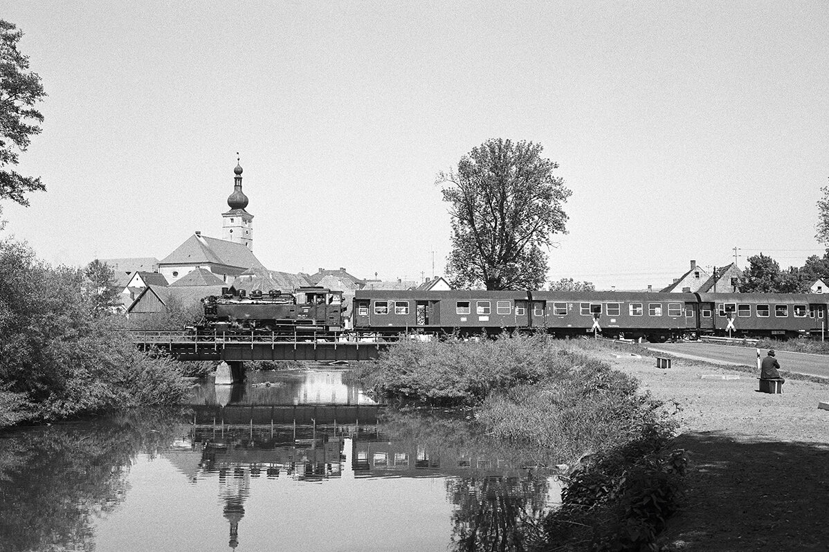 Steam locomotive 64-295 is crossing a bridge in black and white