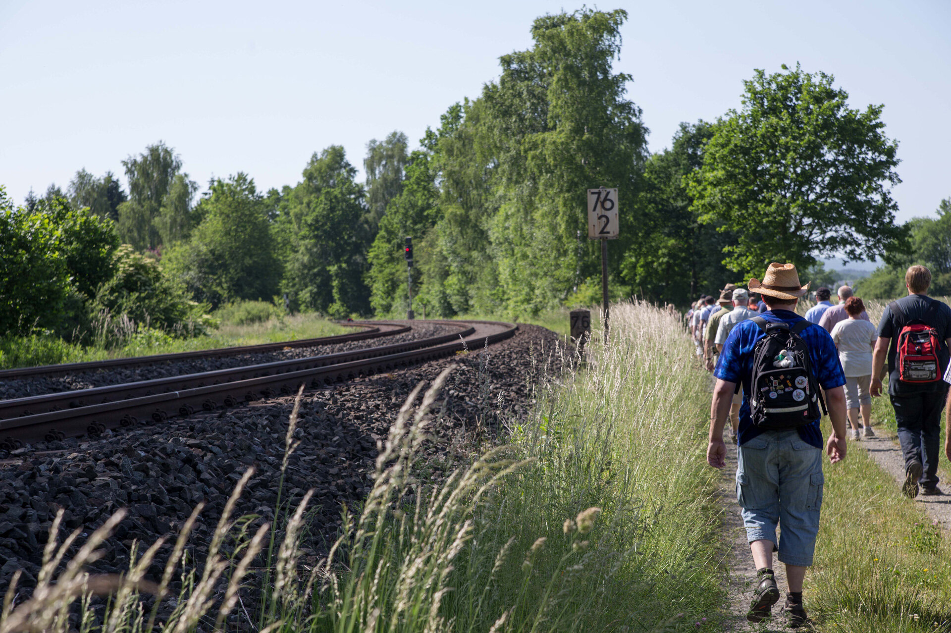 A group of hikers walking along the railway track