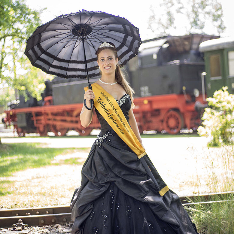 The princess of the coal yard Paula I. with an umbrella, a sash and a tiara