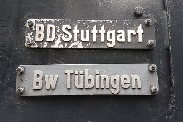 Zwei Schilder mit der Aufschrift "BD Stuttgart" und "Bw Tübingen" an der Lok 38-2383