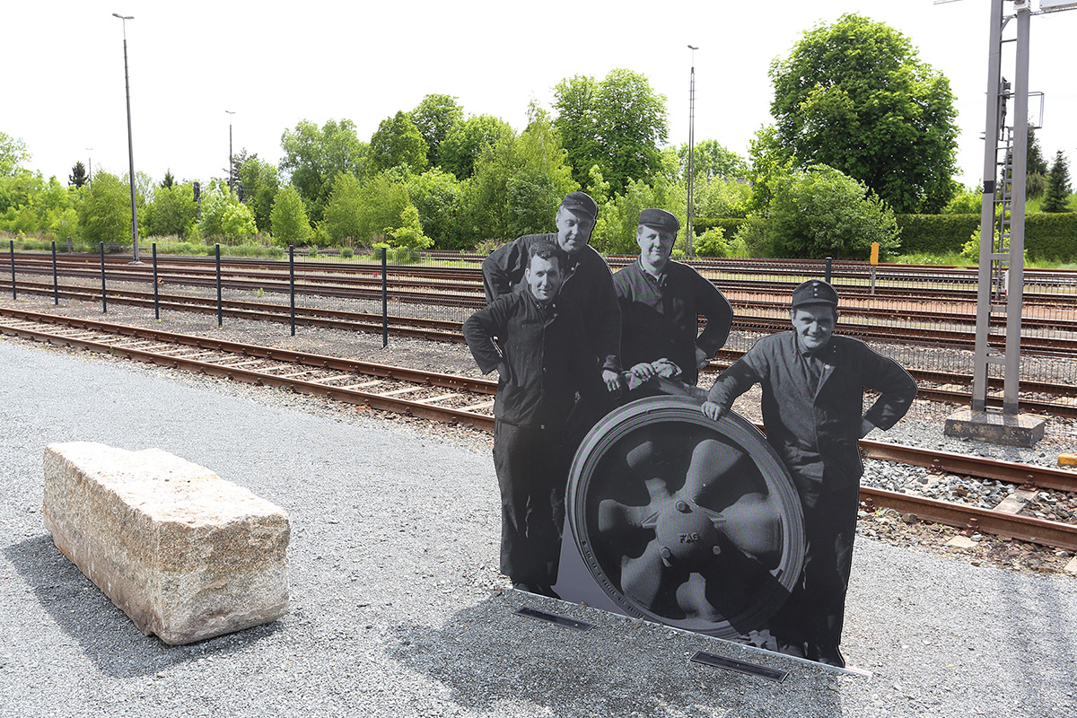 A life-size black and white cut out figurine of a group of workers