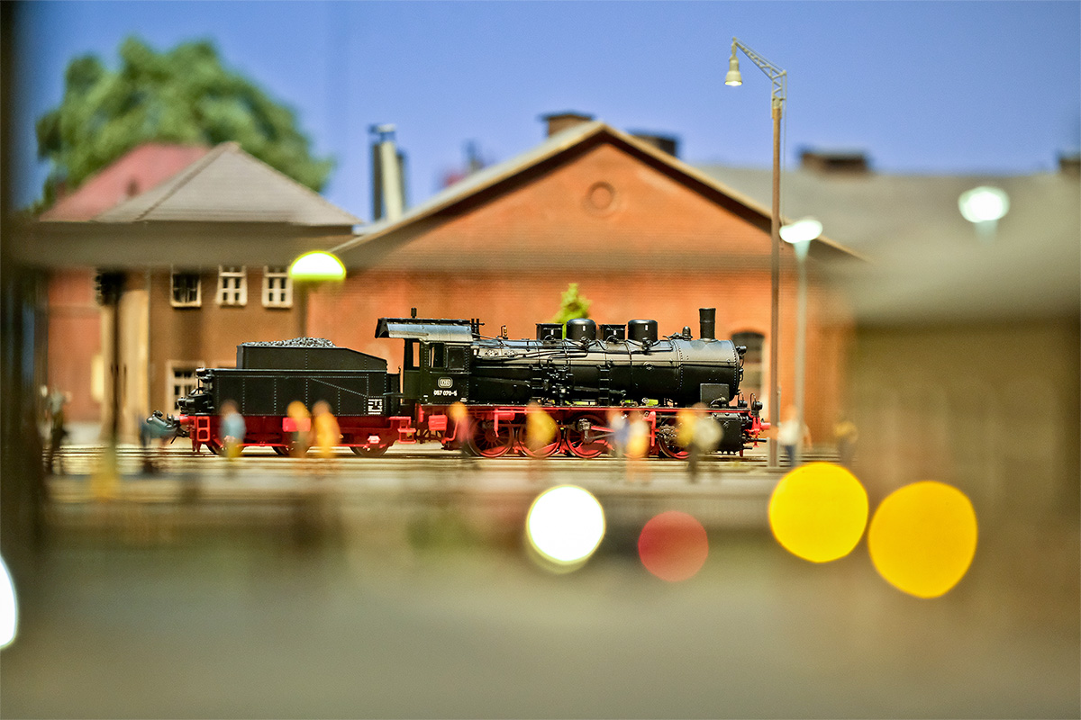 Close-up of a model locomotive in front of the engine shed