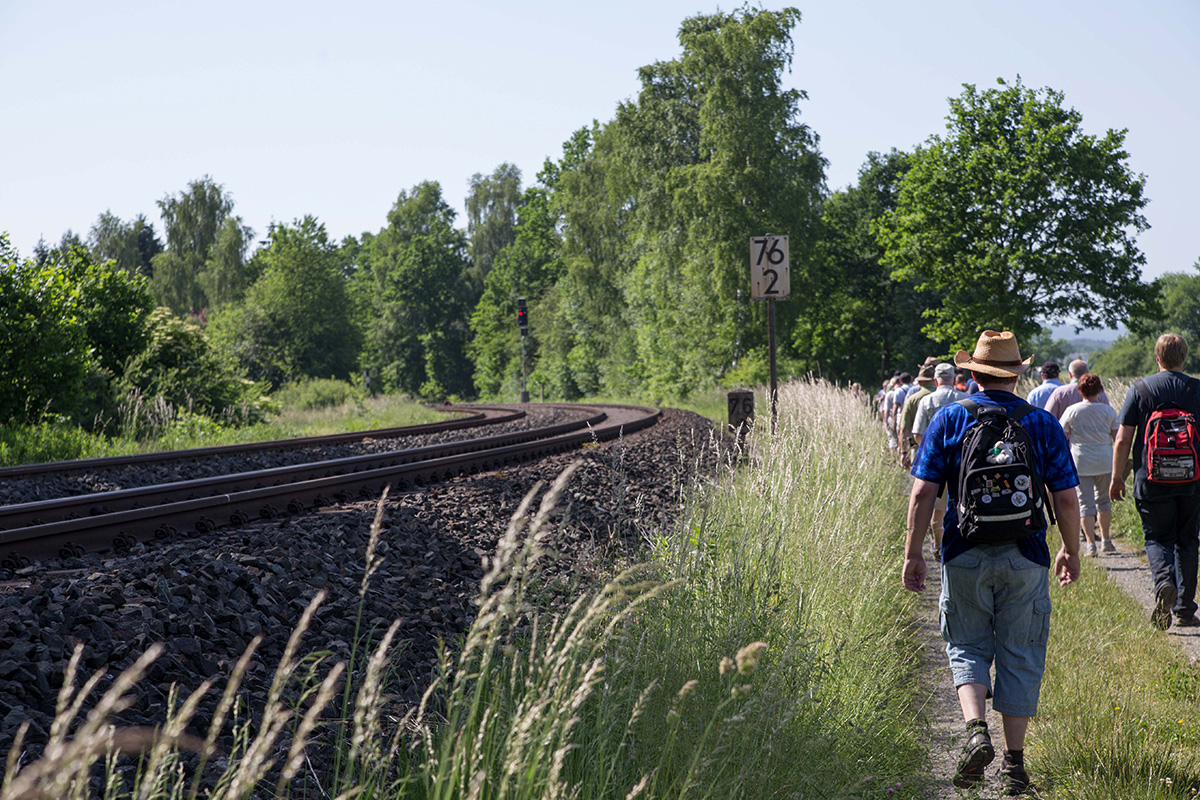 Eine Gruppe von Personen wandert entlang der Eisenbahnstrecke